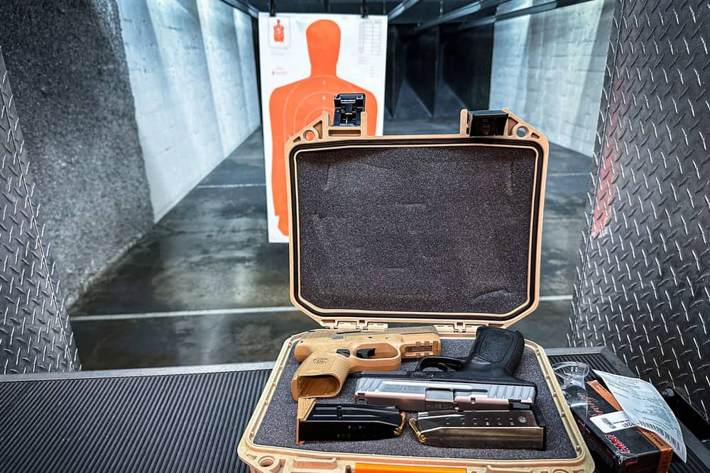 An open hard case holding a handgun and accessories at an indoor range