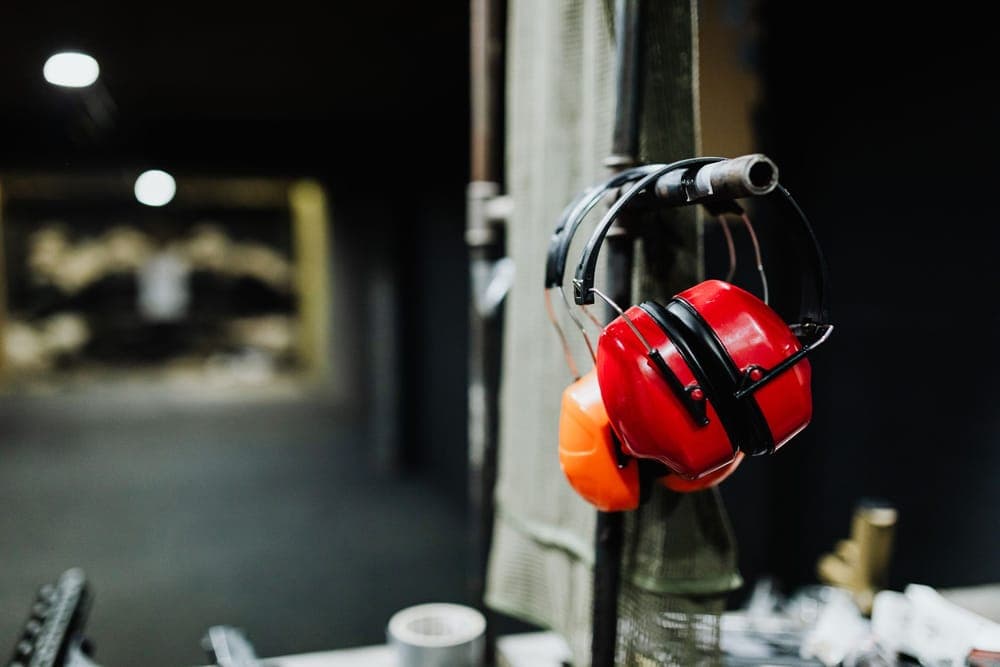 Red earmuffs hanging at an indoor shooting range