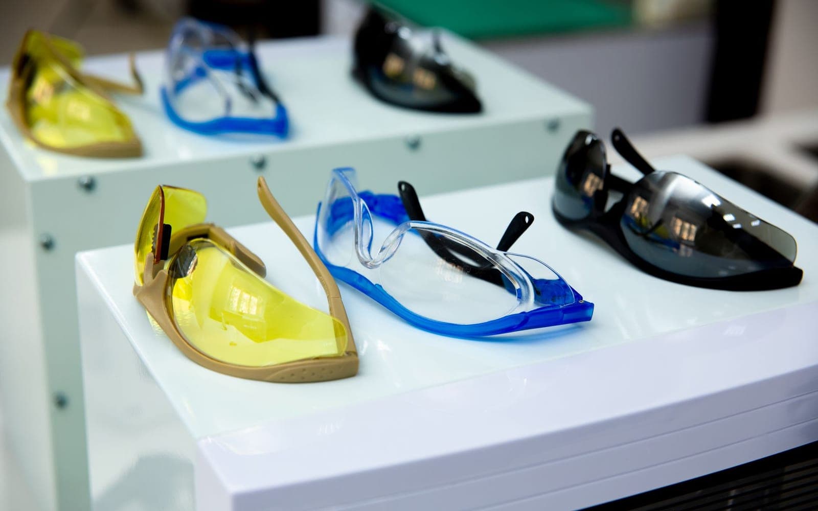Protective glasses with yellow, clear and dark lenses on a display